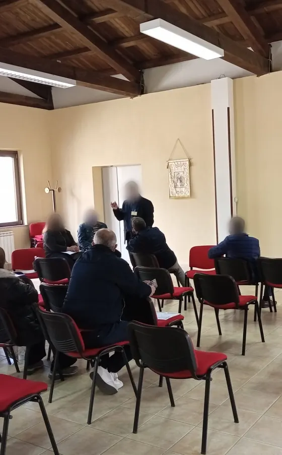 Lezione in aula di un corso Theorema sulla sicurezza: il docente spiega, i corsisti seguono seduti