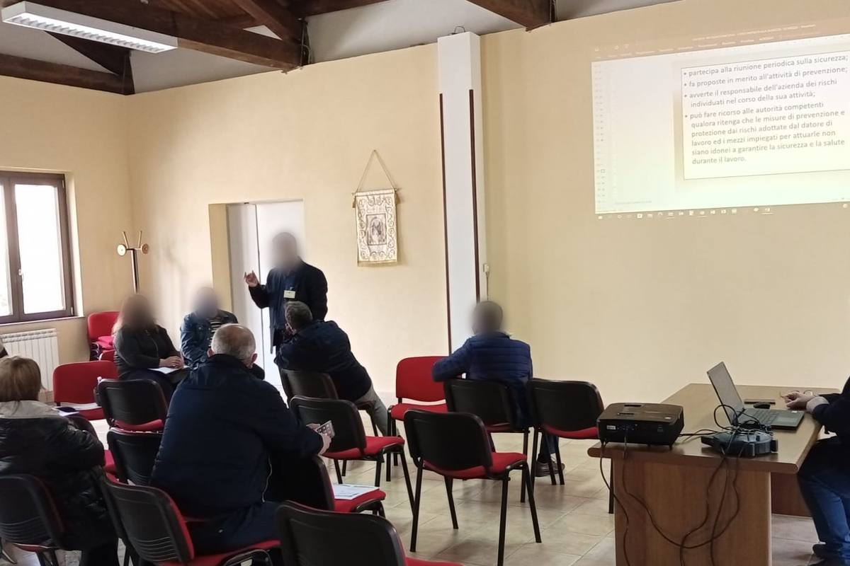 Lezione in aula di un corso Theorema sulla sicurezza: il docente spiega la slide ai corsisti